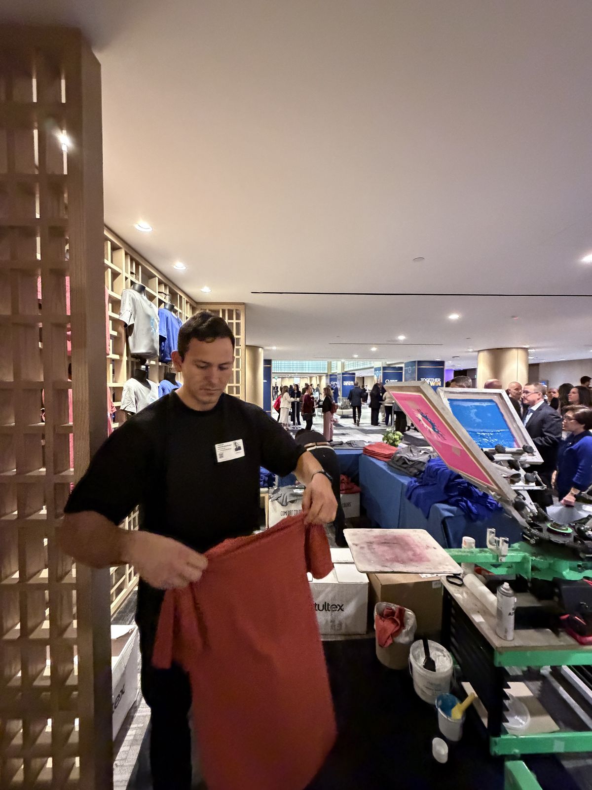 Guests watching custom merch get printed live at a Charlotte event